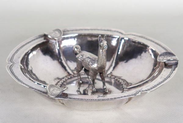 Posacenere in argento sudamericano Titolo 900, cesellato e sbalzato con piccola scultura di lama al centro, gr. 280