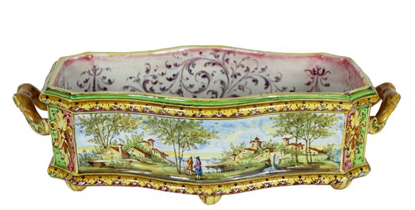 Antico centrotavola in maiolica bolognese policroma, a forma rettangolare centinata con due manici, interamente decorato a motivi di paesaggi. Marcato Ceramiche Artistiche Angelo Minghetti & Figli - A. M. F., Periodo 1900-1918
