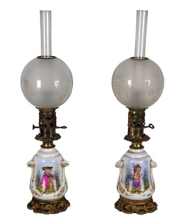 Pair of antique French oil lamps in Old Paris porcelain and bronze, with painted panels with portraits of a nobleman and noblewoman, canulae and glass globes. A globe is broken