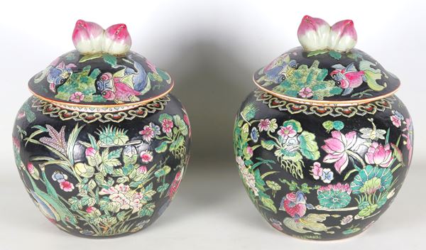Coppia di potiches cinesi in porcellana smaltata nera, interamente decorate con smalti policromi a rilievo a motivi di fiori orientali, farfalle e pappagalli
