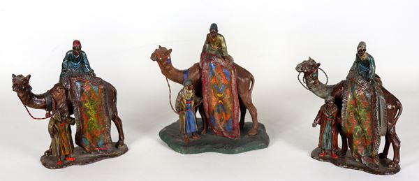 "Carpet sellers with camels", lot of three small sculptures in decorated and polychrome metal