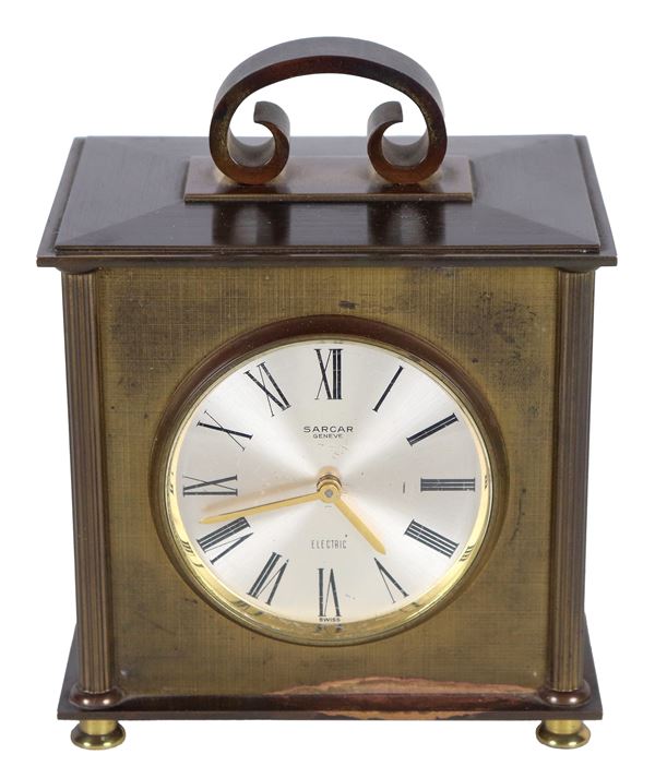 Small rectangular table clock in golden metal, with small handle on the lid and dial signed Sarcar Genève, battery-operated electric mechanism. 50s - 60s