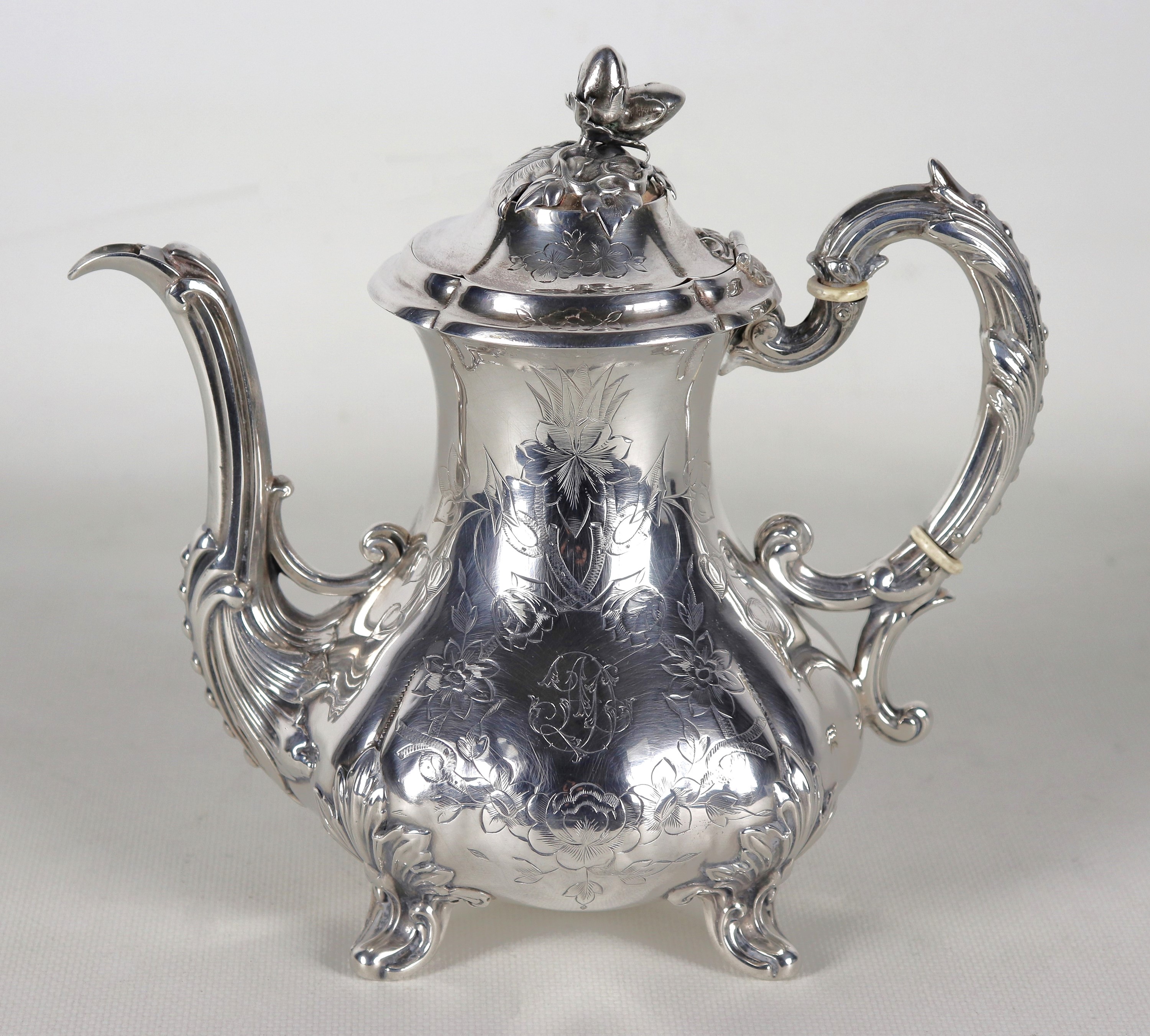 Antica caffettiera in argento, cesellato e sbalzato a volute floreali e monogramma inciso, manico...