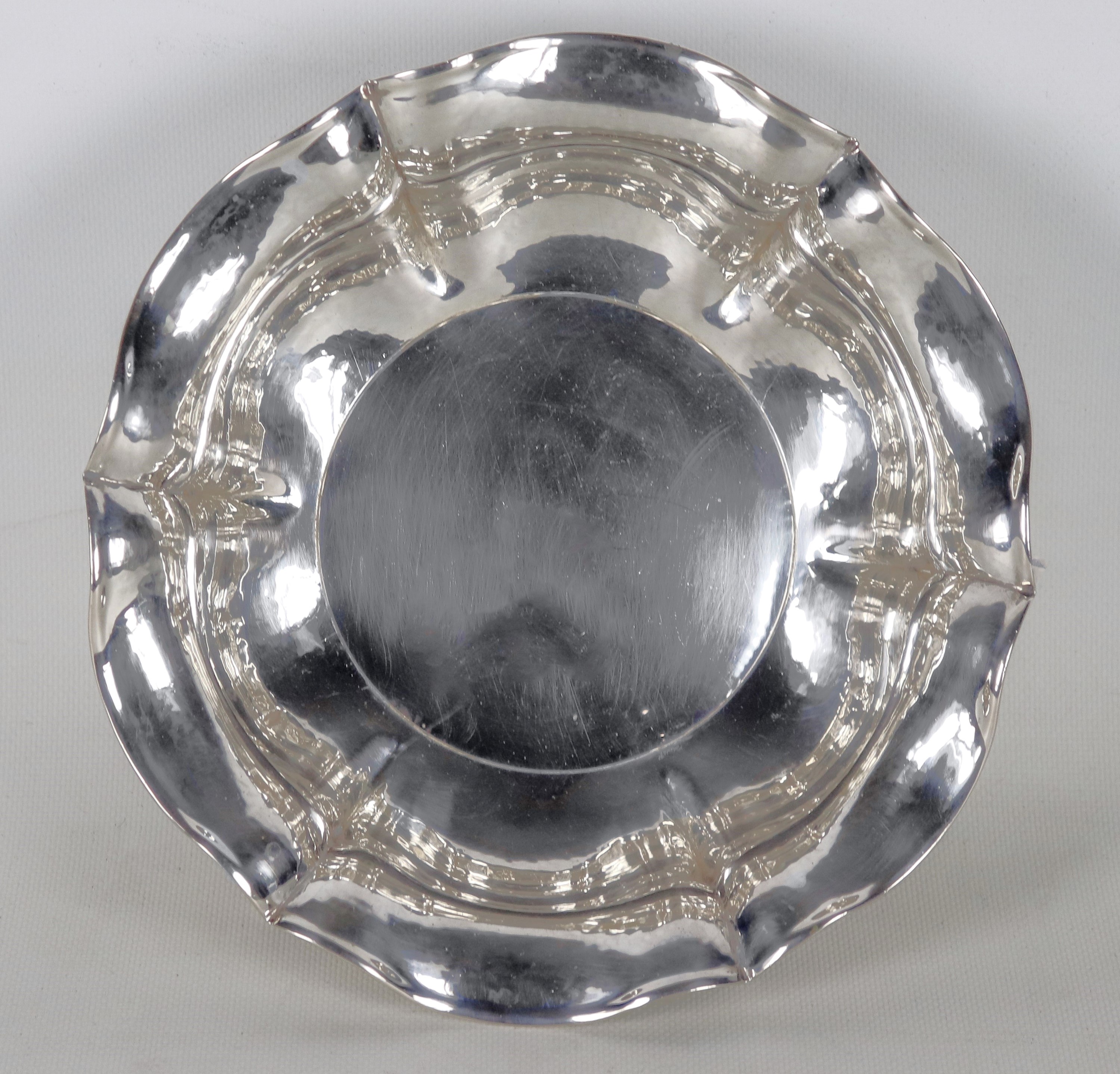 Fruttiera tonda in argento cesellato e sbalzato con bordo centinato, gr. 490