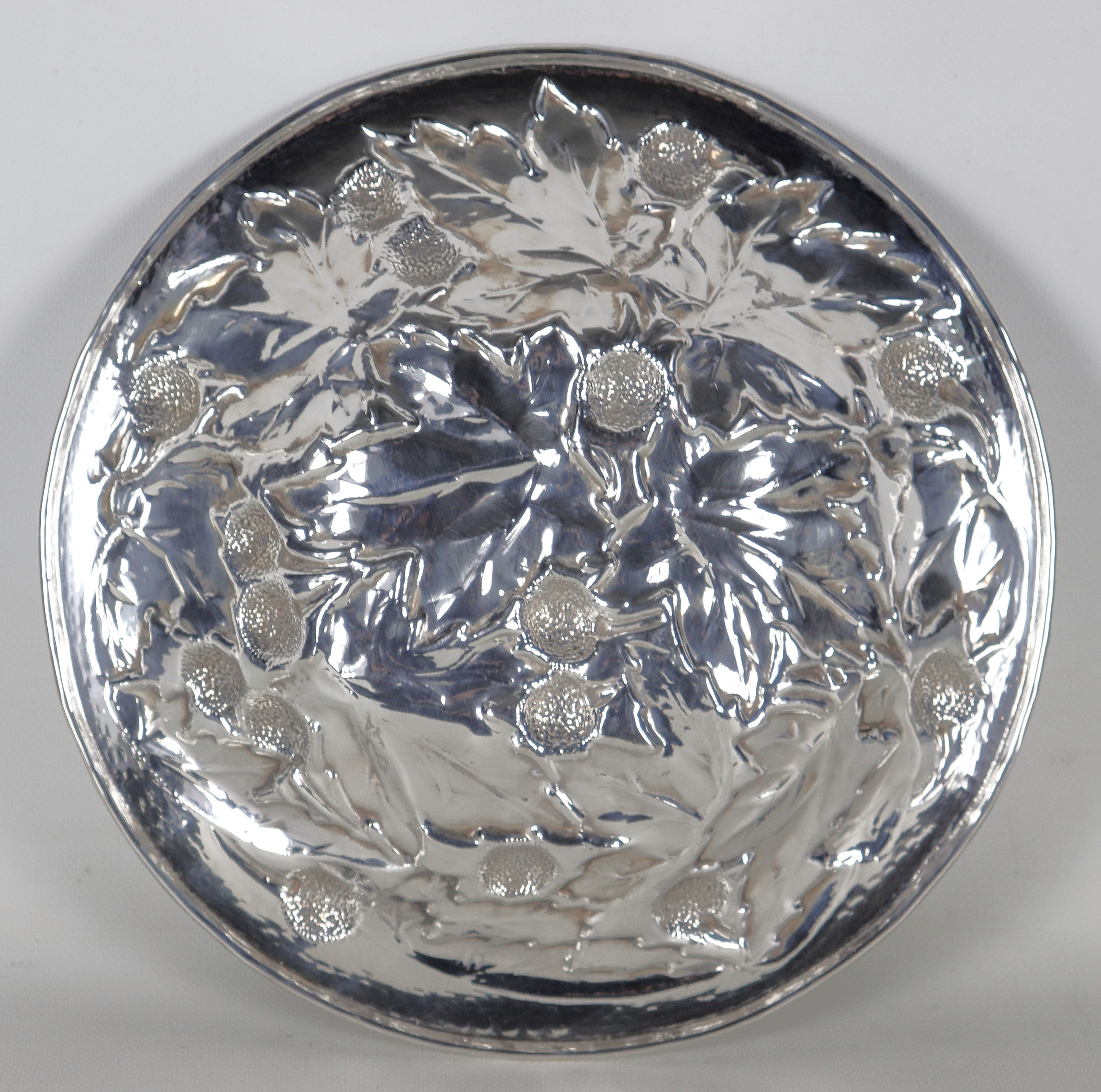 Fruttiera tonda in argento, interamente cesellata e sbalzata a motivi di foglie e frutti, gr. 640