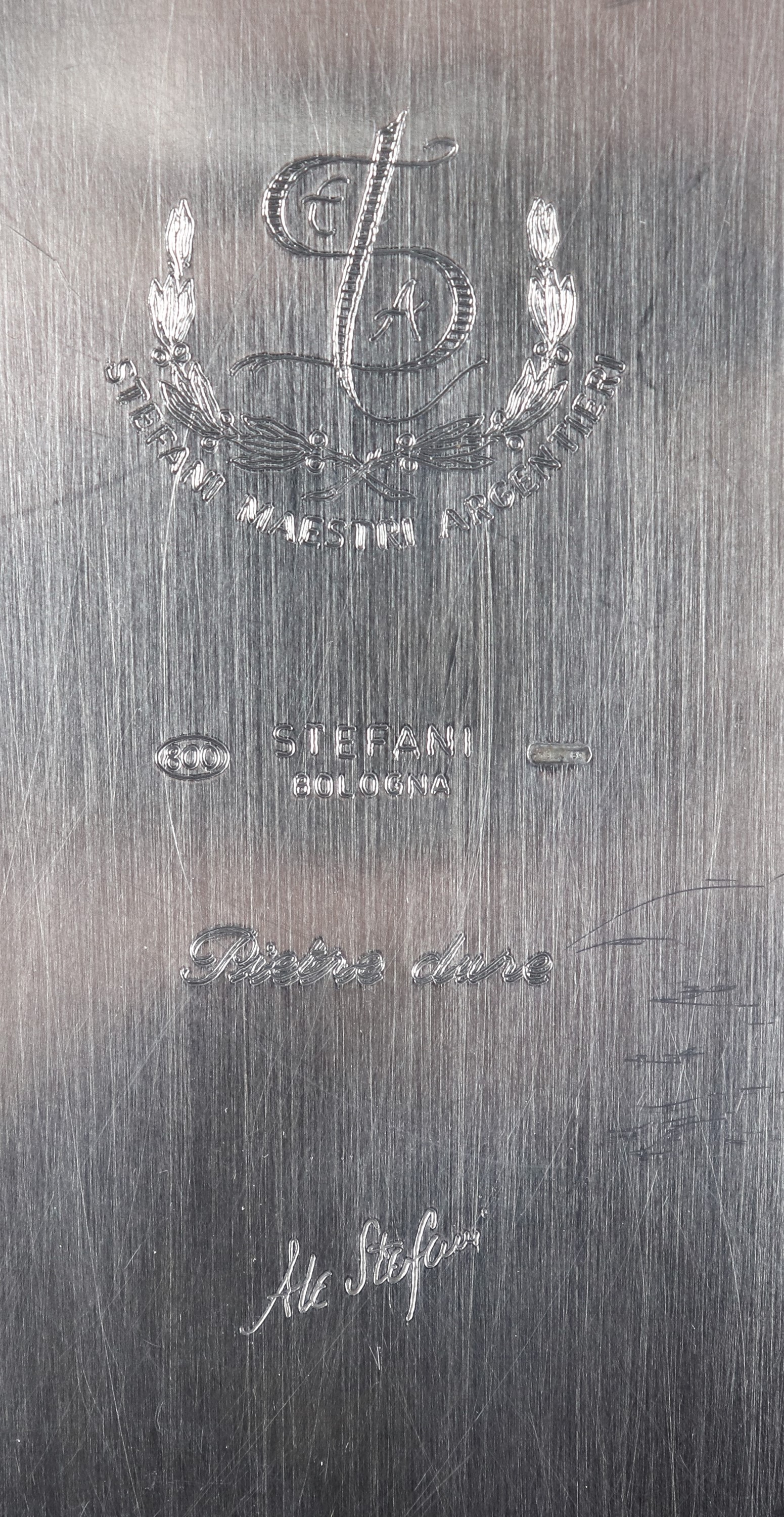 Grande centrotavola in argento, con applicazioni sul bordo di volute dorate e pietre dure. Marcat...