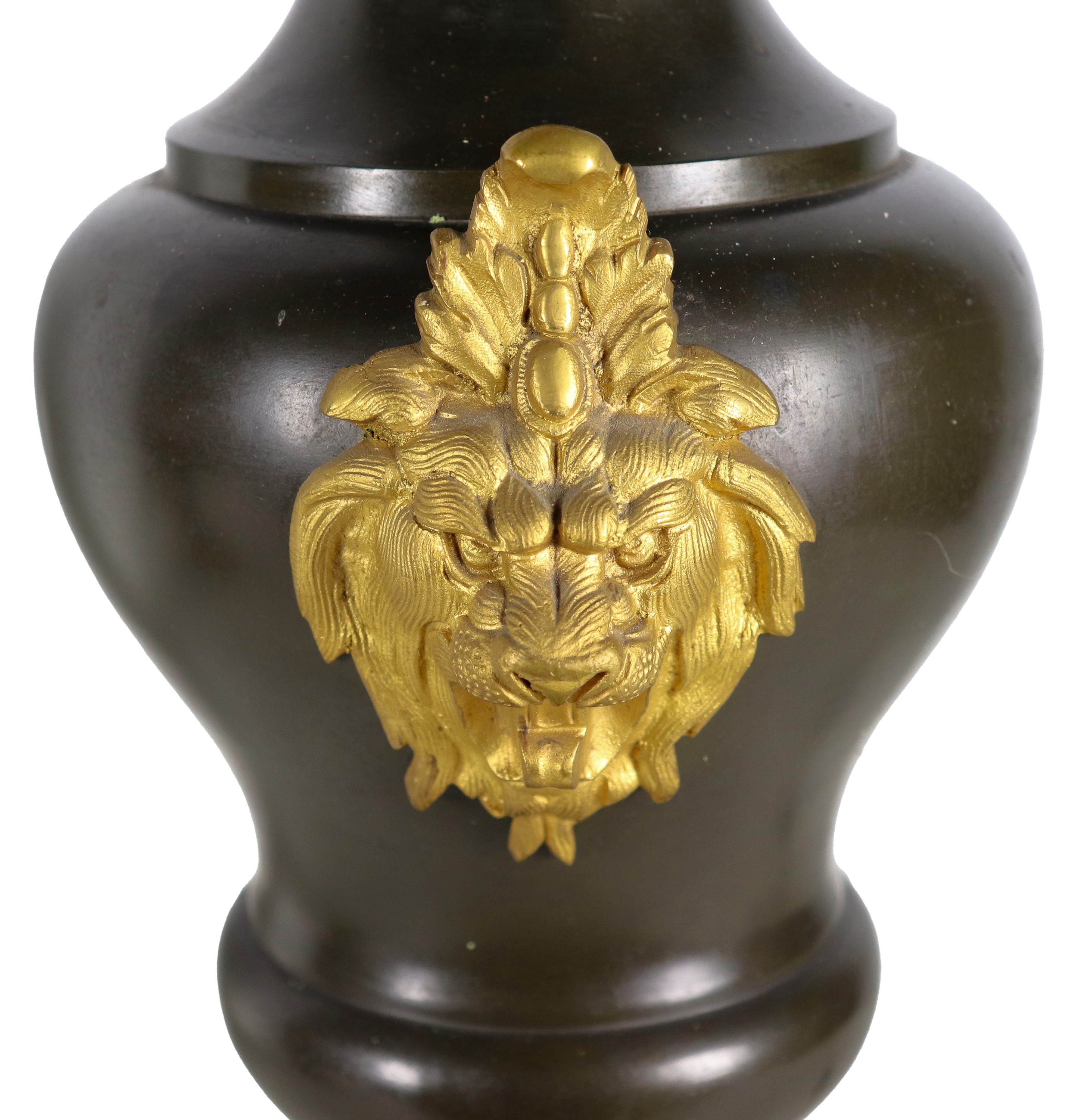 Coppia di anfore francesi in metallo laccato nero, con teste di leoni in bronzo dorato e cesellat...