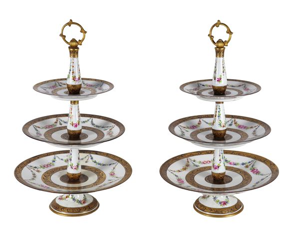 Pair of three-tier porcelain cake stands, with polychrome floral festoon decorations and pure gold edges. Old single-storey restoration of a cake stand.