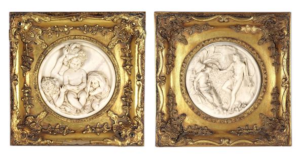 Pair of marble dust medallions with mythological scene and cherubs, gilded wooden frames