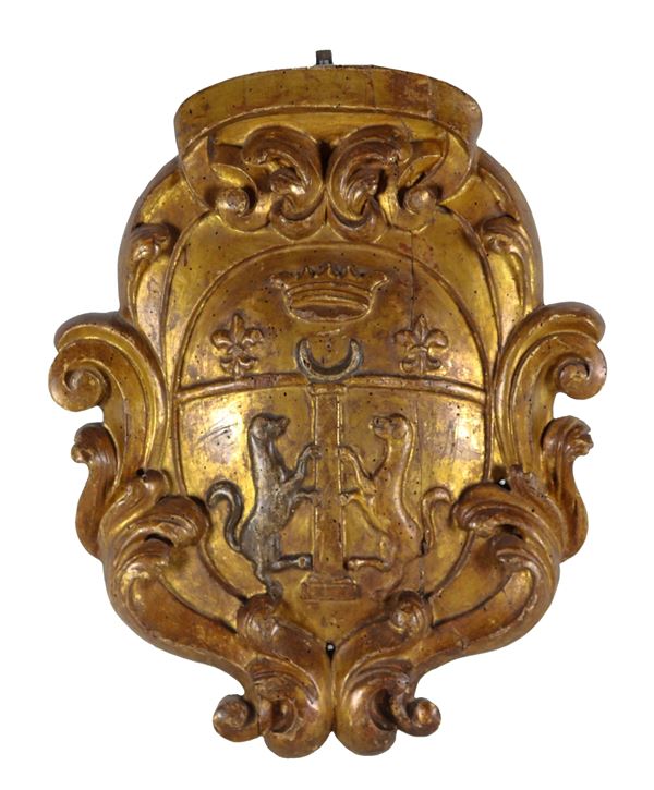 Ancient noble coat of arms in gilded and carved wood