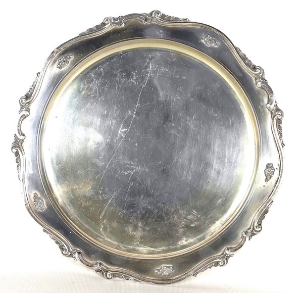 Piatto tondo in argento, con bordo sbalzato e cesellato a volute, gr. 570