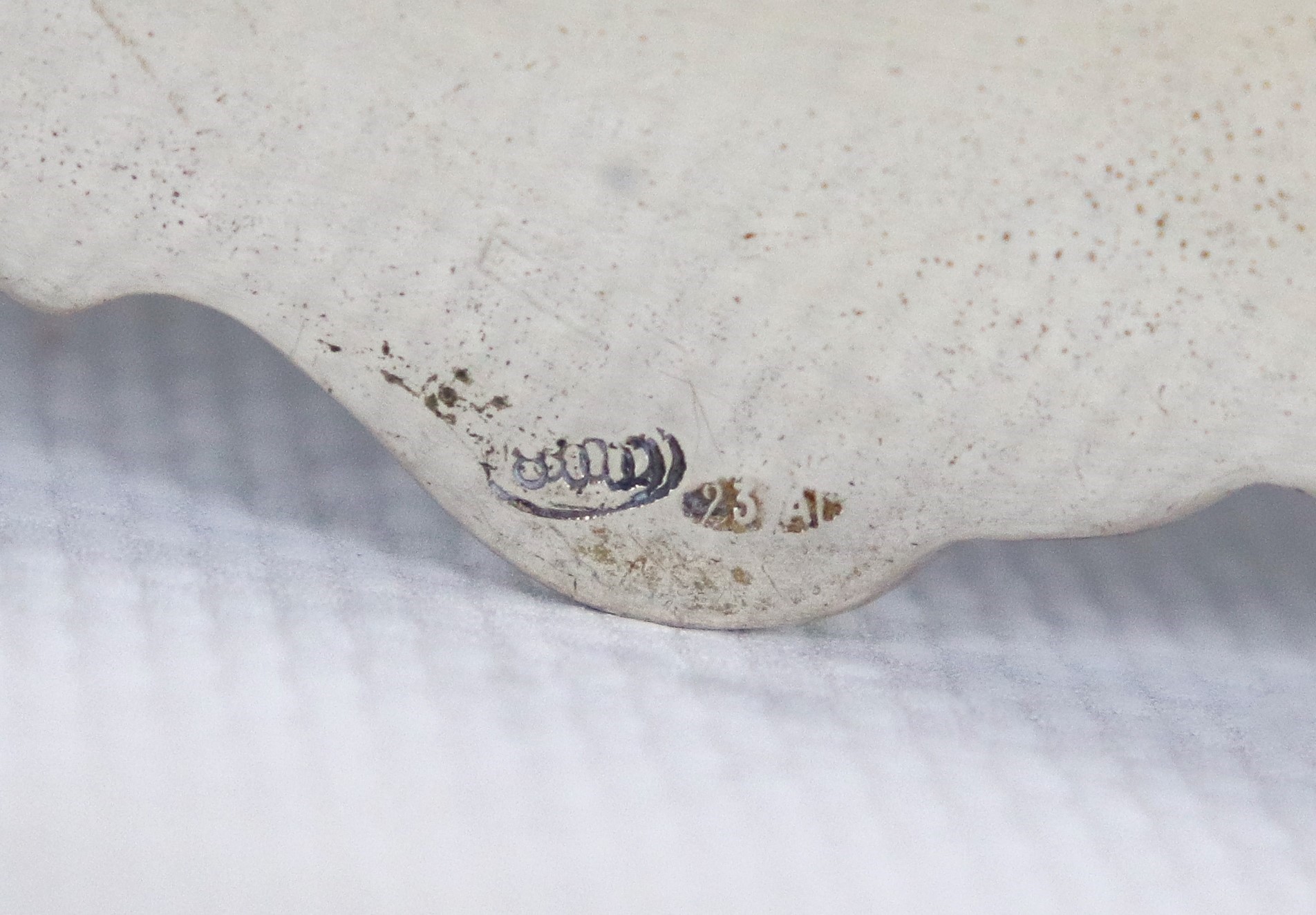 Piatto tondo in argento, con bordo sbalzato e cesellato a volute, gr. 570