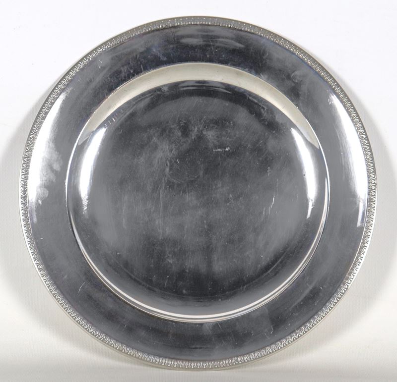 Piatto tondo da portata in argento, con bordo cesellato e sbalzato a motivi Impero, gr. 660