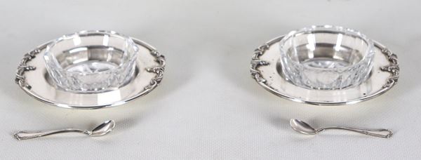 Coppia di salierine tonde in argento con bordi sbalzati, due vaschette in cristallo e due cucchiaini, gr. 170