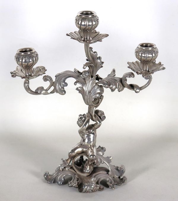 Candelabro in argento cesellato e sbalzato a motivi Luigi XV, sorretto da scultura di putto, 3 fiamme, gr. 1600