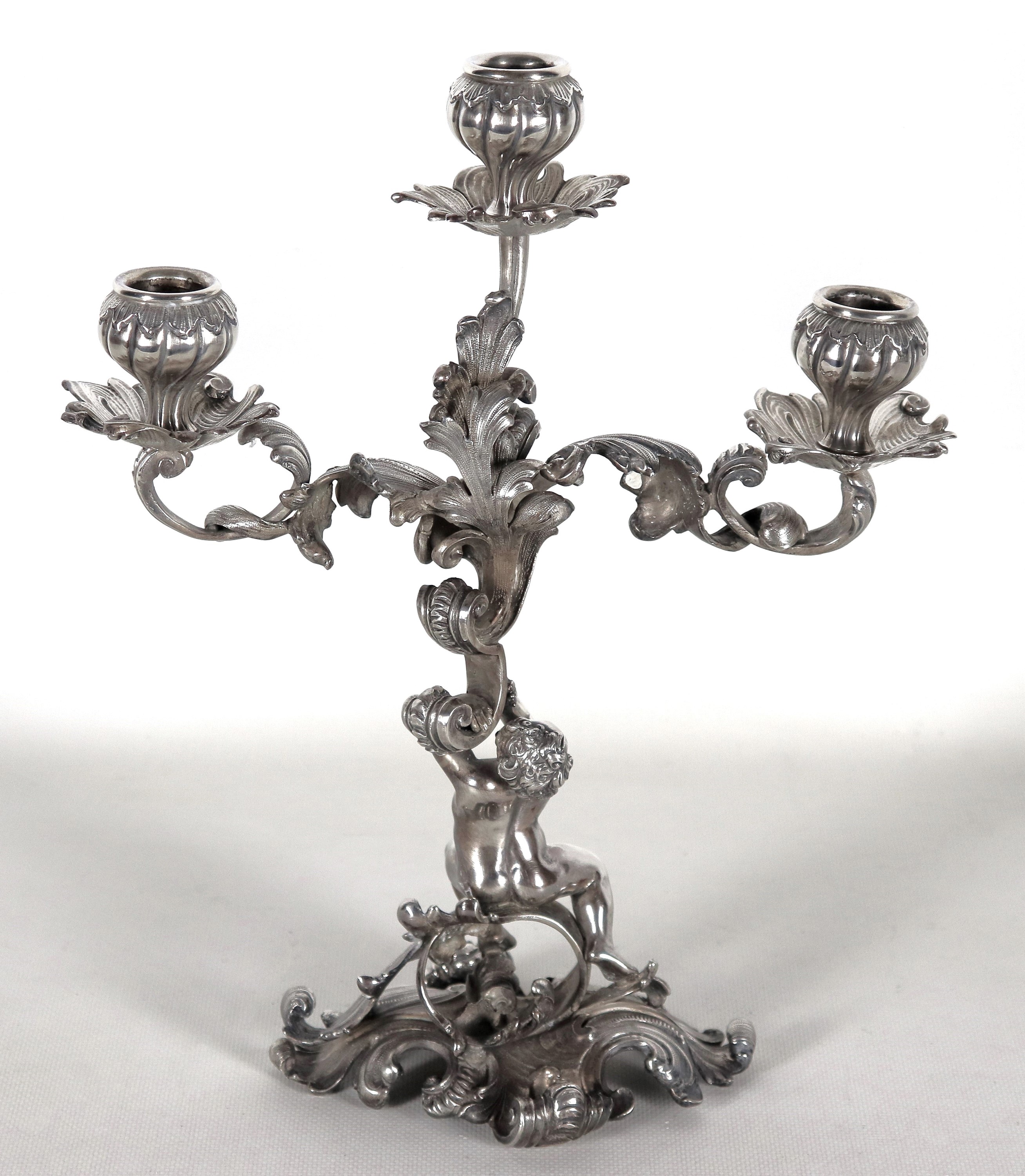 Candelabro in argento cesellato e sbalzato a motivi Luigi XV, sorretto da scultura di putto, 3 fi...