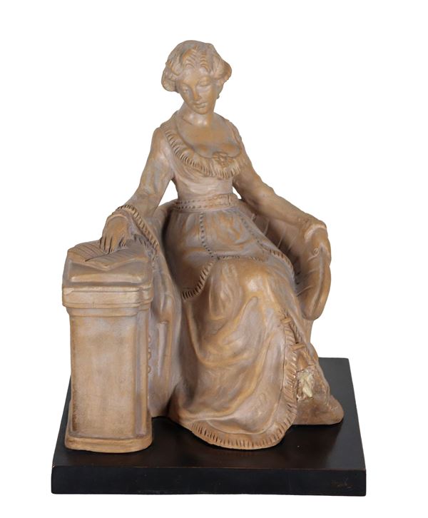 Giovanni Nicolini - Firmato. "Dama in poltrona con libro", gruppo in ceramica patinata, sorretto da base quadrangolare in legno. La dama manca di un piedino