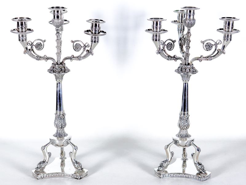 Coppia di candelabri in argento cesellato e sbalzato a motivi Primo Impero, quattro fiamme ciascu...
