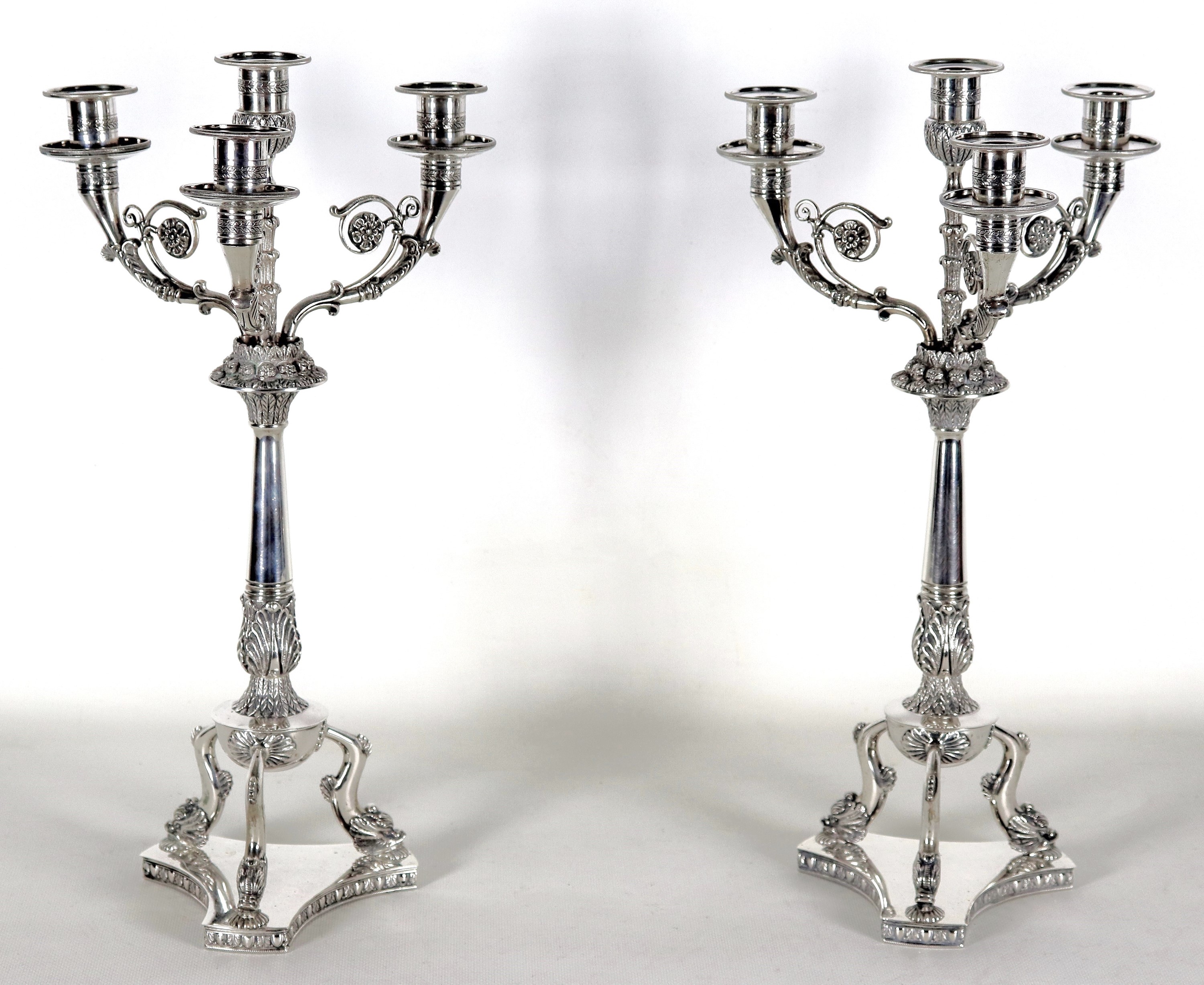 Coppia di candelabri in argento cesellato e sbalzato a motivi Primo Impero, quattro fiamme ciascu...