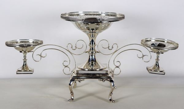 Ancient English Epergne in silver George V period, chiselled, embossed and pierced, with central basket and two baskets on the sides supported by shaped volutes. Quadrangular perforated base, supported by four curved legs. Stamps Sheffield 1919 Silversmith J.R., gr. 3590