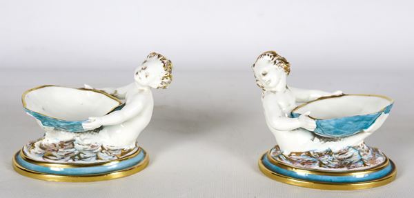 "Giovani tritoni con conchiglie", coppia di saliere in porcellana inglese policroma di Royal Worcester  