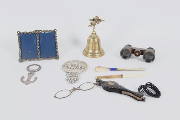 Set of a mouthpiece, a small letter opener, a pair of opera glasses, a small mirror, a magnifying glass, a table bell, a picture frame and removable spectacles, (8 pcs)