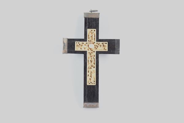 Ebonized wooden cross with carved scenes in the center, silvered trimmings