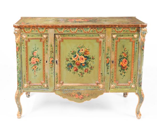 Venetian Louis XVI style sideboard, lacquered in green and decorated with bunches of polychrome flowers with masks on the uprights, three doors and four curved legs