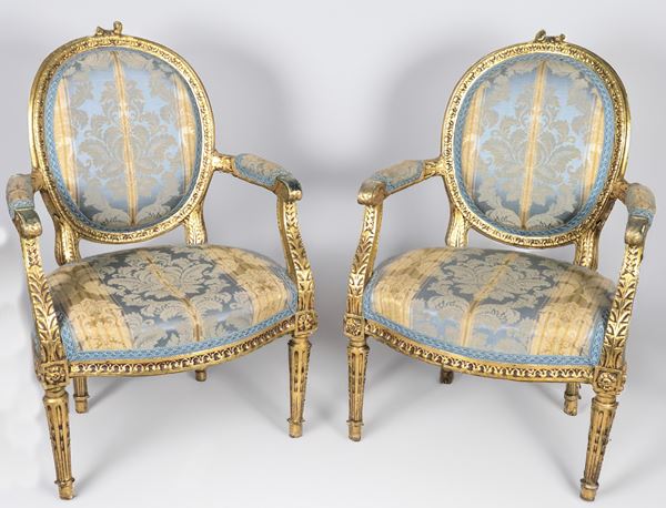 Pair of French armchairs of Louis XVI line in gilded wood and carved with neoclassical motifs, curved armrests and four fluted cone legs