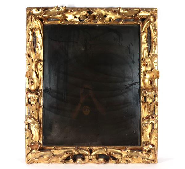 Antique gilded wooden frame carved with intertwined leaf motifs, defective mercury mirror with lateral breakage