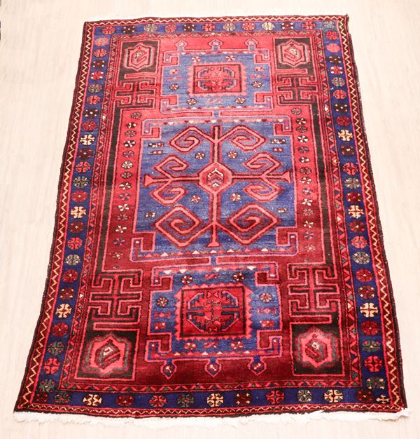 Kazakh Persian carpet with geometric designs on a red and light blue background