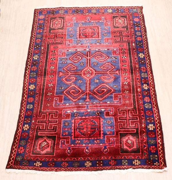 Kazakh Persian carpet with geometric designs on a red and light blue background