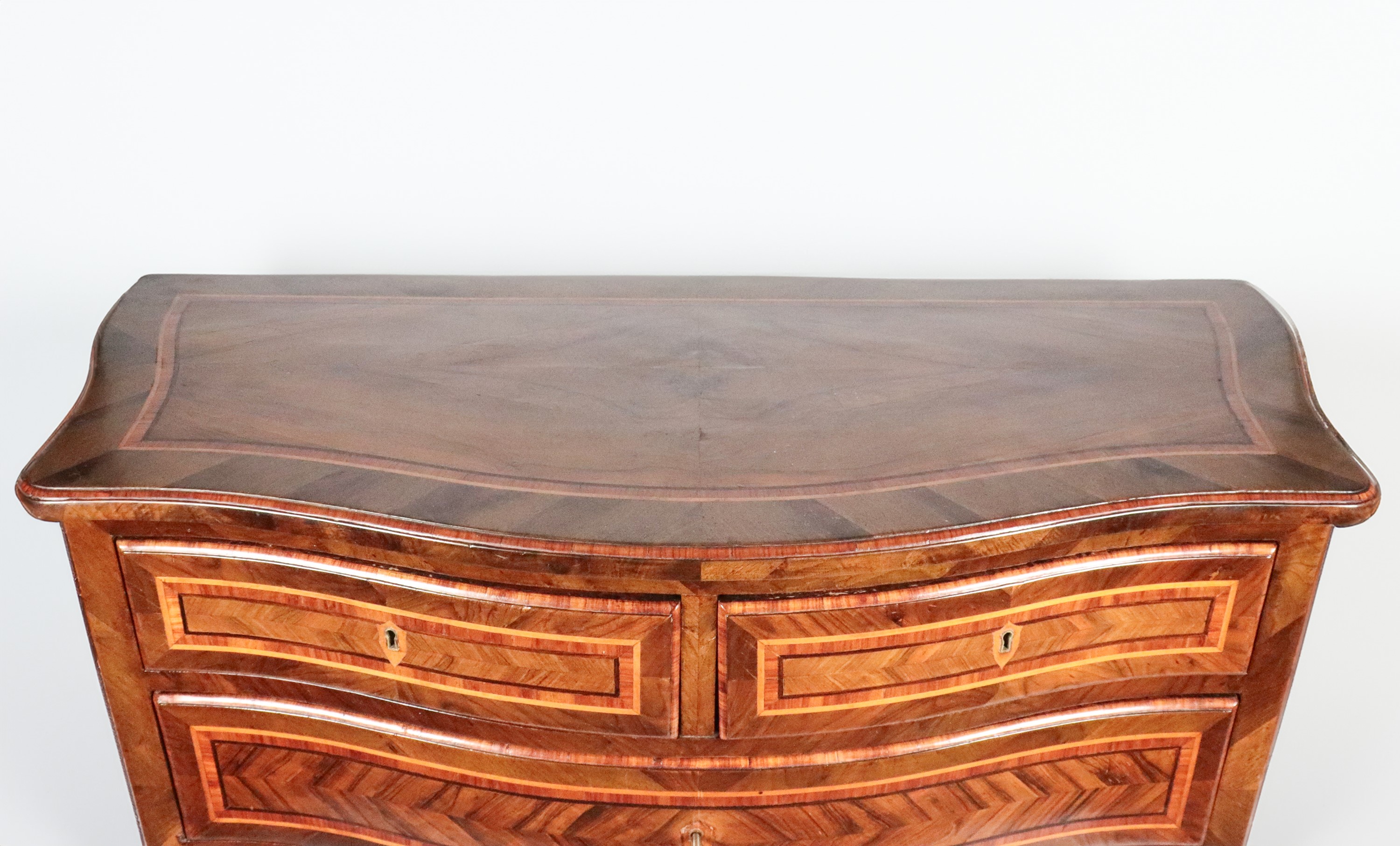 Antico cassettone romano di linea Luigi XV, in noce, bois de rose ed ebano viola, con filettature...