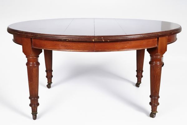 Antique English oval extendable dining table in mahogany, with four fluted and turned cone legs, two extension tables and crank opening mechanism