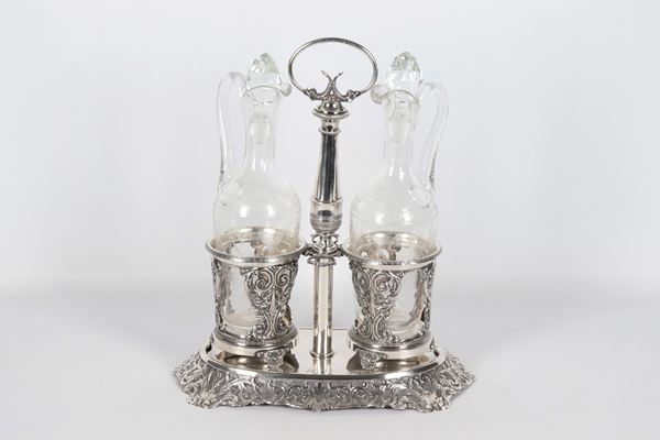 Antique French oil cruet in silver, chiseled and embossed with Louis XVI motifs of acanthus leaf scrolls, shells, dolphins and monogram engraved on the base, two crystal ampoules with matching stoppers. Stamps France Late 18th Century, gr. 580