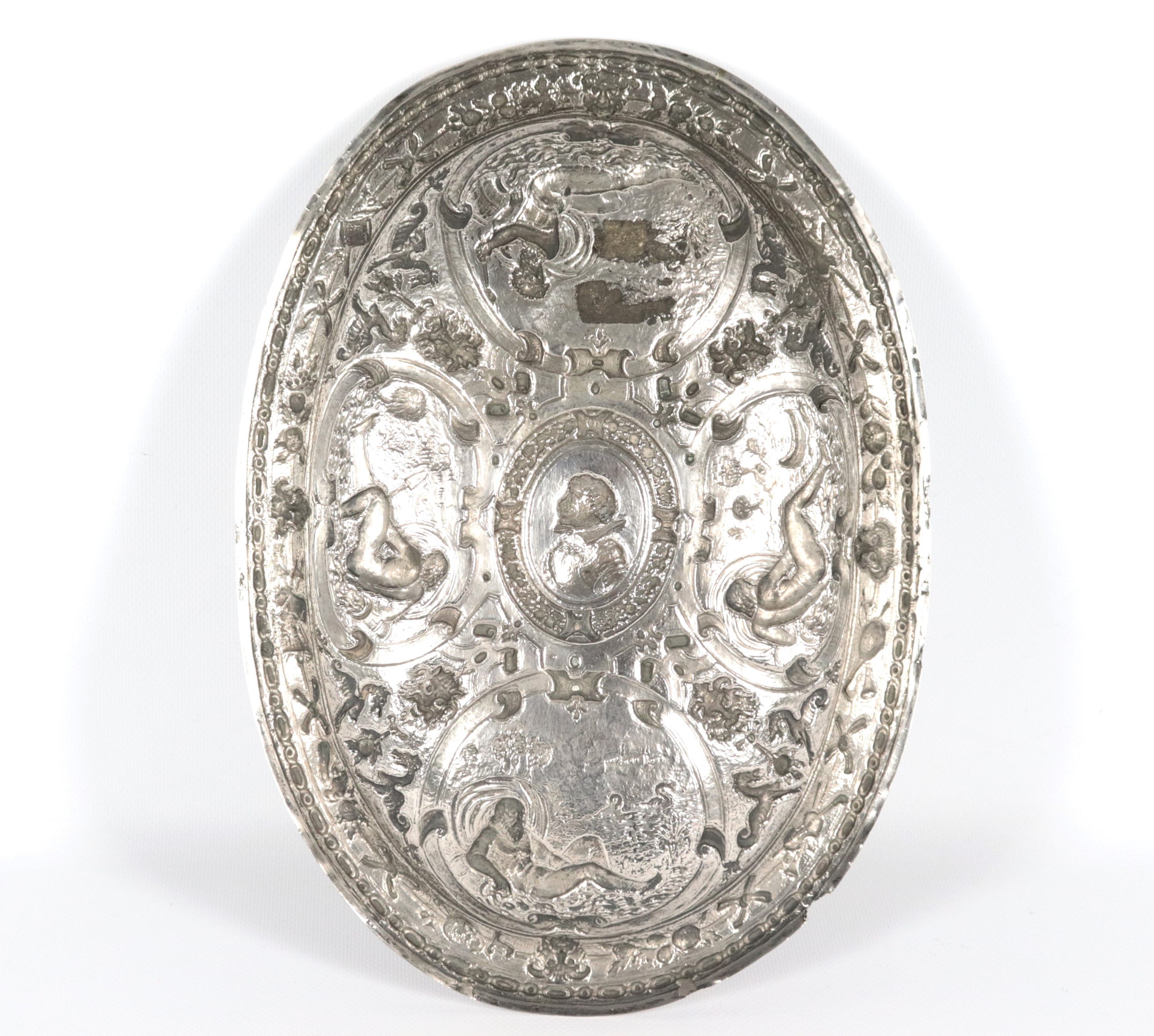 Antico piatto da parata in argento a forma ovale, riccamente cesellato e sbalzato ad altorilievo ...