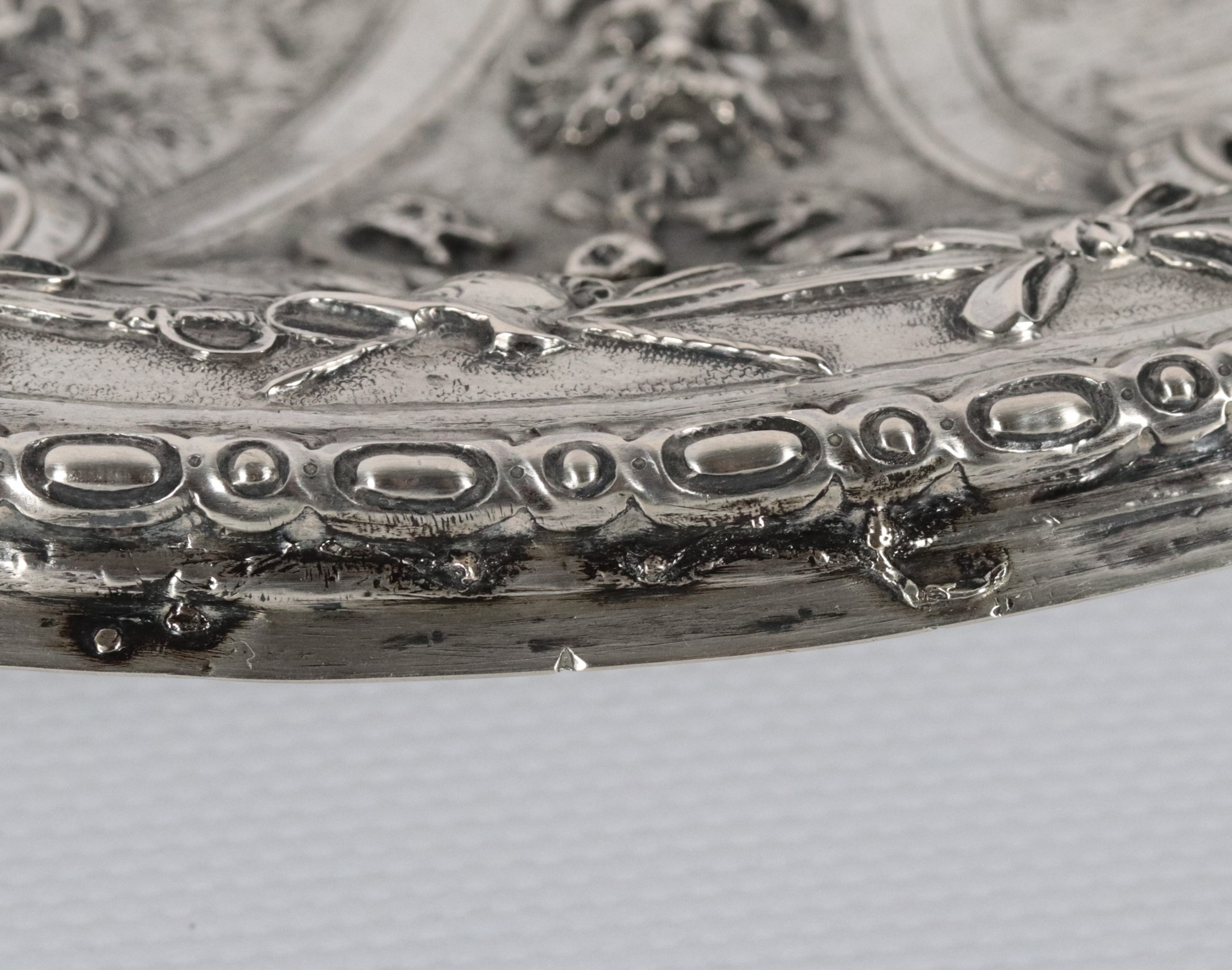 Antico piatto da parata in argento a forma ovale, riccamente cesellato e sbalzato ad altorilievo ...