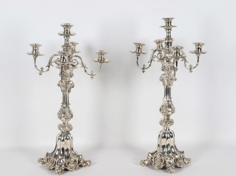 Coppia di antichi candelabri francesi in argento cesellato e sbalzato a motivi di volute, grappol...