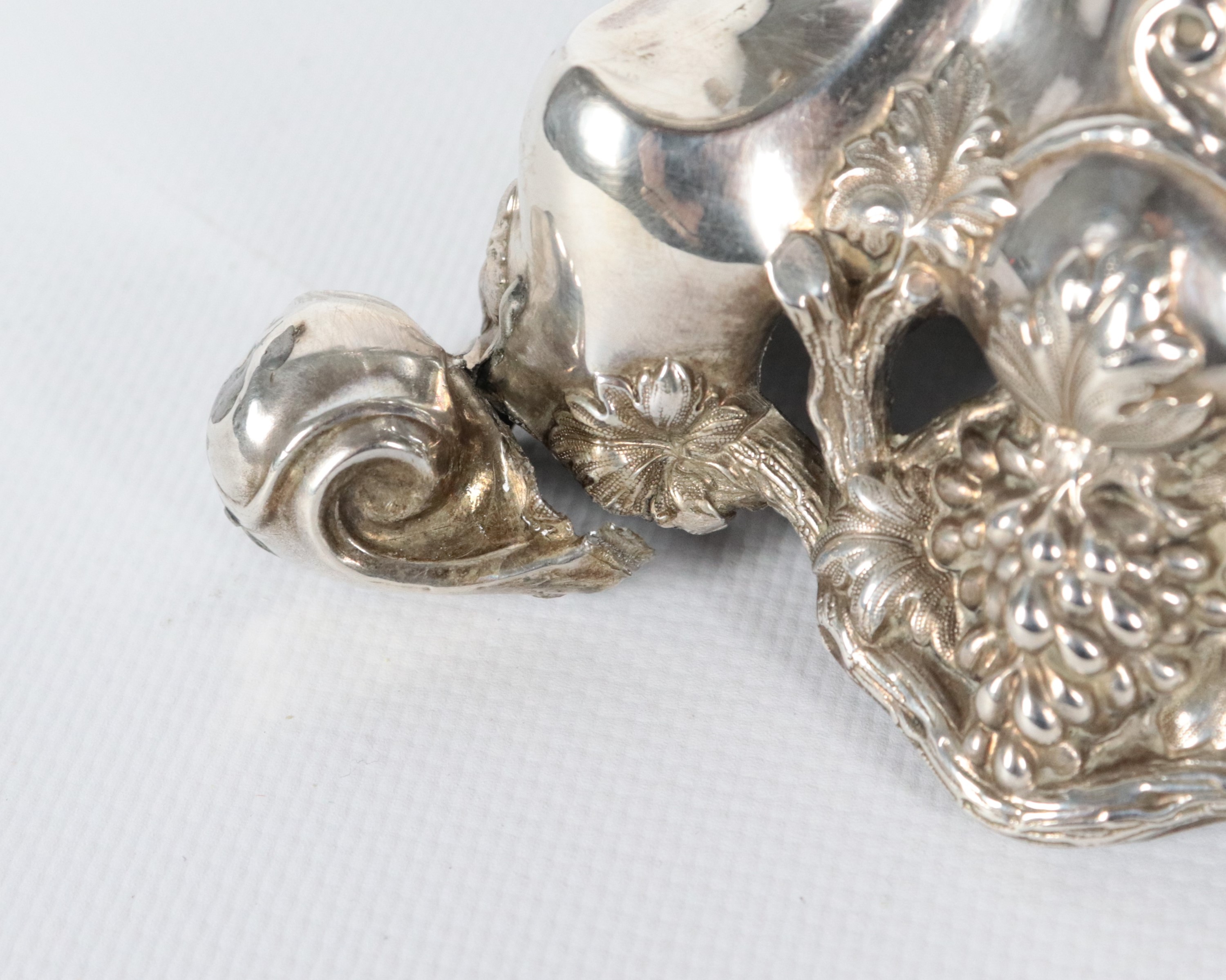 Coppia di antichi candelabri francesi in argento cesellato e sbalzato a motivi di volute, grappol...