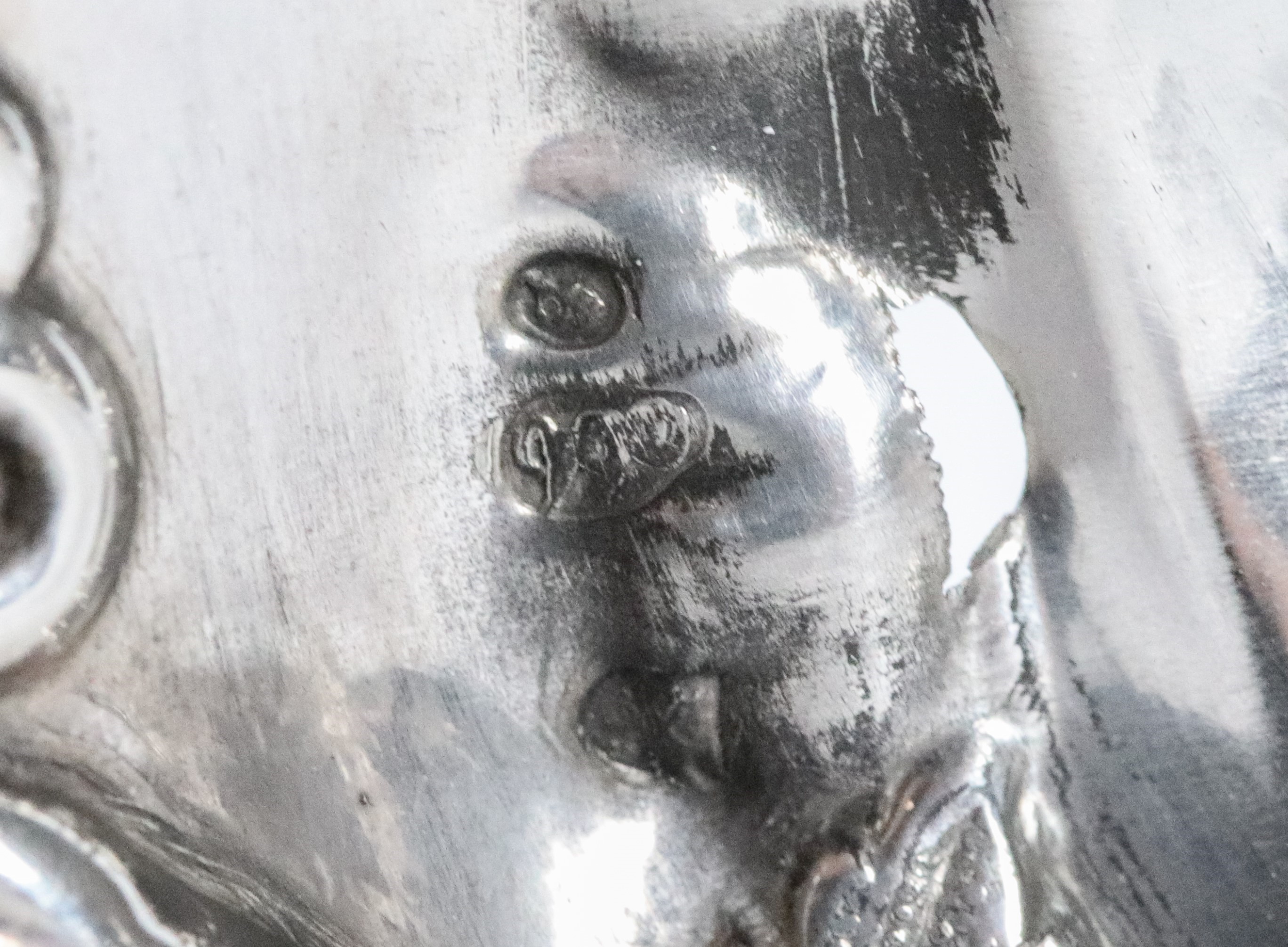 Coppia di antichi candelabri francesi in argento cesellato e sbalzato a motivi di volute, grappol...