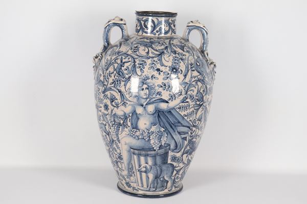 Antico orcio in maiolica italiana, con decorazioni dipinte in blu a volute di fiori e animali, sul davanti e ai due manici mascheroni a rilievo