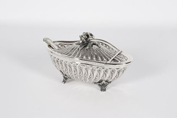 Oval-shaped silver cheese bowl, entirely chiseled and embossed with floral pods and scrolls, with a flower-shaped knob and four curved feet, inside a crystal bowl. Manufacture: Late 19th century, gr. 315