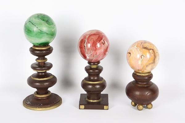 Lot of three wooden spheres decorated with fake marble, with turned column bases