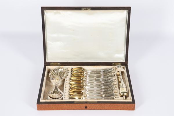 Antique French tea set in chiseled and embossed silver, with twelve spoons, a sugar tong, a strainer and a ladle (15 pieces), mahogany case with monogram on the lid, gr. 260