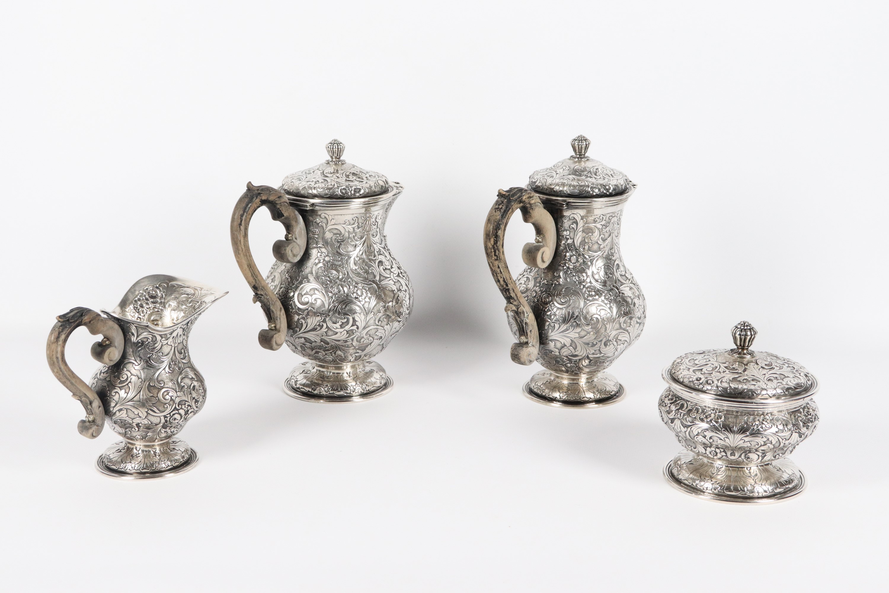 Antico servizio da caffè in argento, riccamente cesellato e sbalzato a rilievo a motivi di volute...
