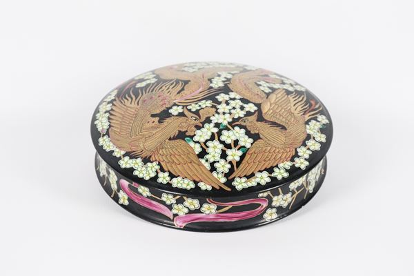 Round porcelain box, decorated and colorful with exotic flower and bird motifs on a black background 