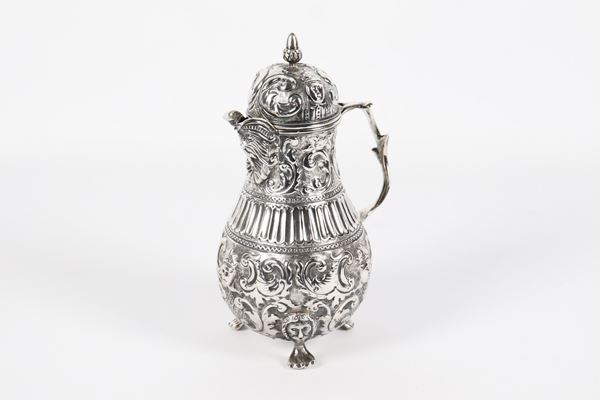 Antique small French coffee pot in silver, entirely chased and embossed with motifs of curls and masks, supported by three feet in the shape of lion heads, breakage at the spout. French stamps, late 18th century, 200 gr.