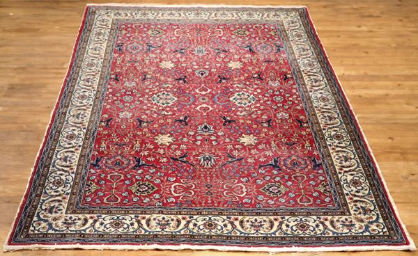 Mashad Persian rug with floral designs on a red background and avana border