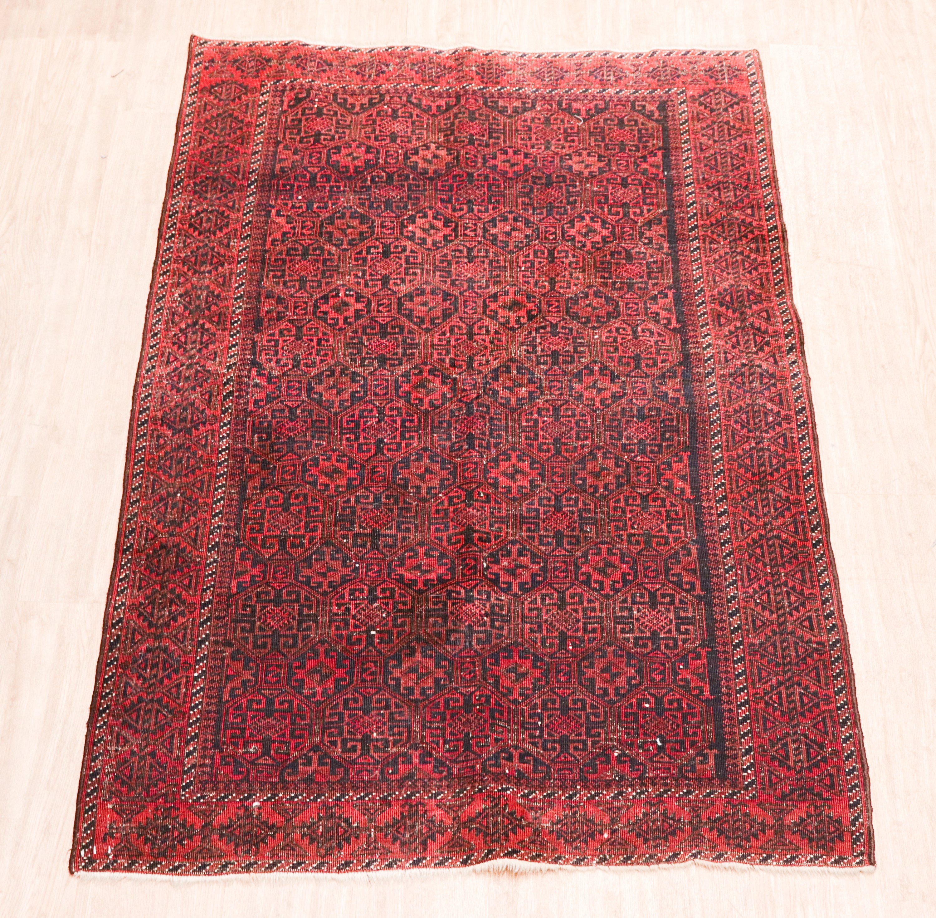 Tappeto persiano Baluch a disegni geometrici su fondo rosso