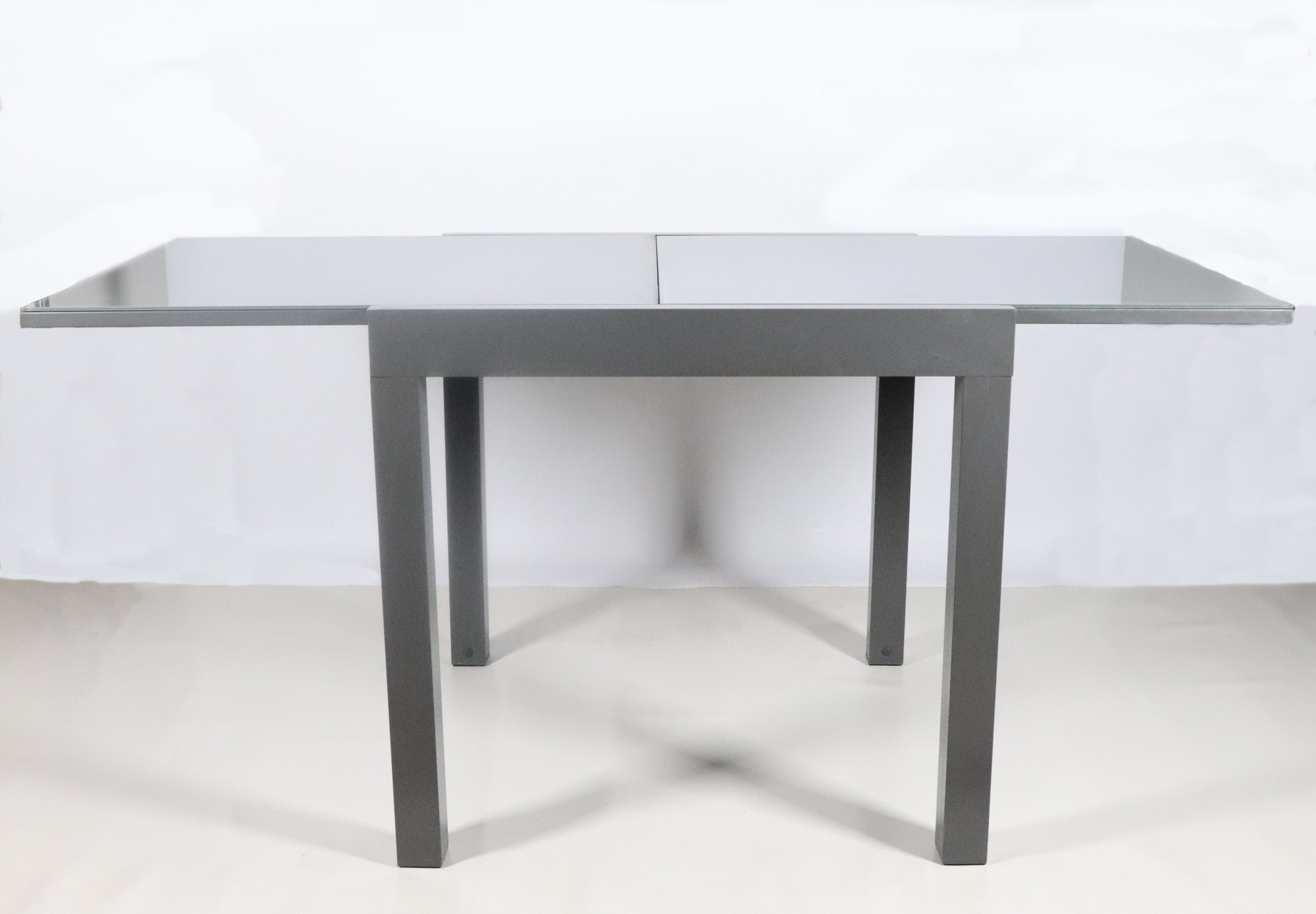 Tavolo quadrato in alluminio e vetro allungabile, quattro gambe quadrangolari. Anni '80